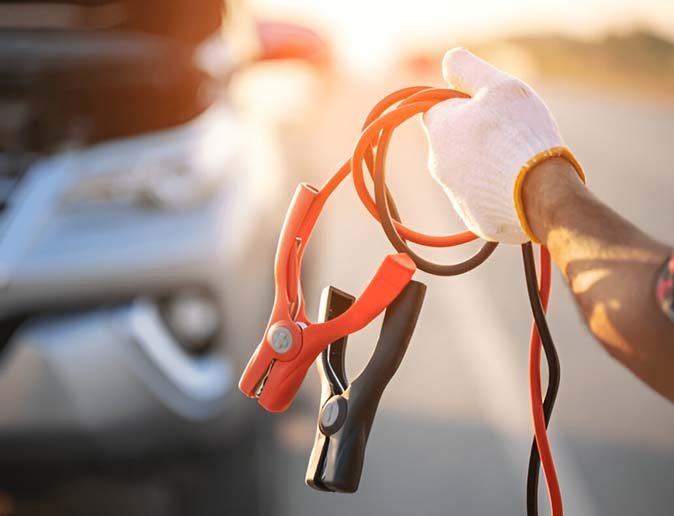 Technician performing a safe vehicle jump start